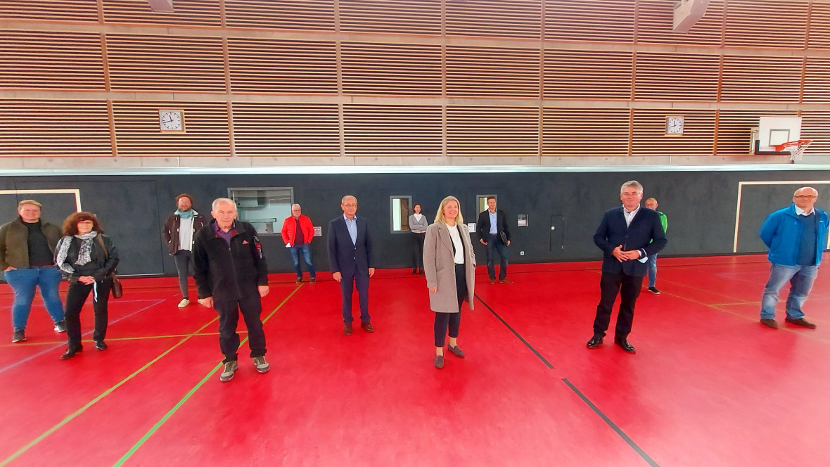 Bürgermeisterin Sabine Heidrich (m.) zeigt Winfried Mack die neue Sporthalle. Beim Besuch waren auch zahlreiche Vertreter des Gemeinderats, der Vereine und der Unternehmen dabei.